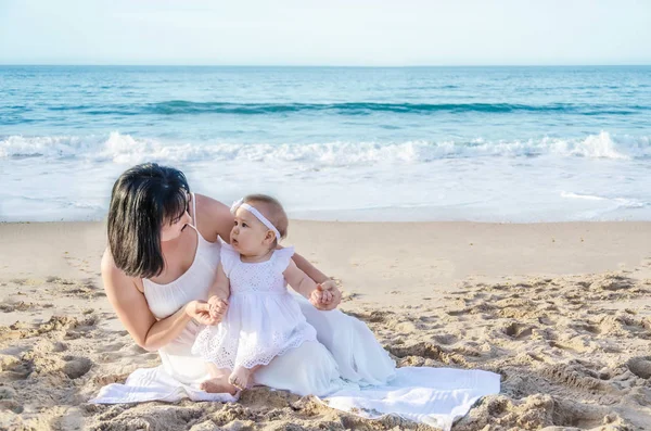 Mother and her baby girl on the sandy beach — Stock Photo, Image