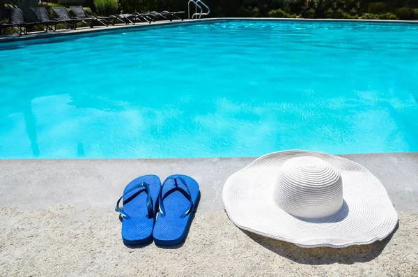 Zomer hoed in de omgeving van en flip flops het zwembad — Stockfoto