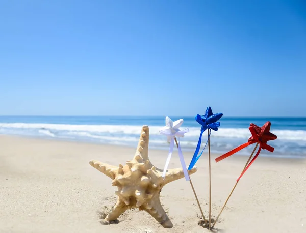 Patriotische USA Hintergrund mit Seesternen am Sandstrand — Stockfoto