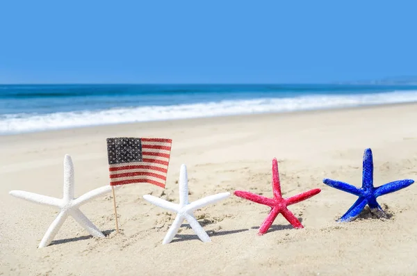 Fondo patriótico de EE.UU. con estrellas de mar en la playa de arena — Foto de Stock