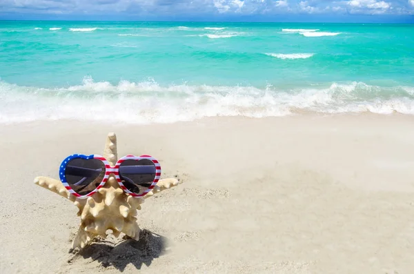 Patriottische Usa achtergrond met zeester op het zandstrand — Stockfoto