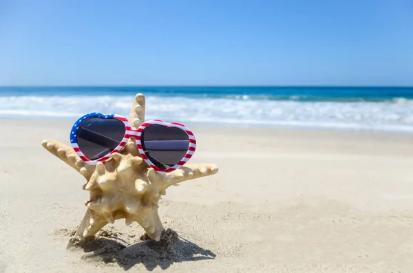 Patriottische Usa achtergrond met zeester op het zandstrand — Stockfoto