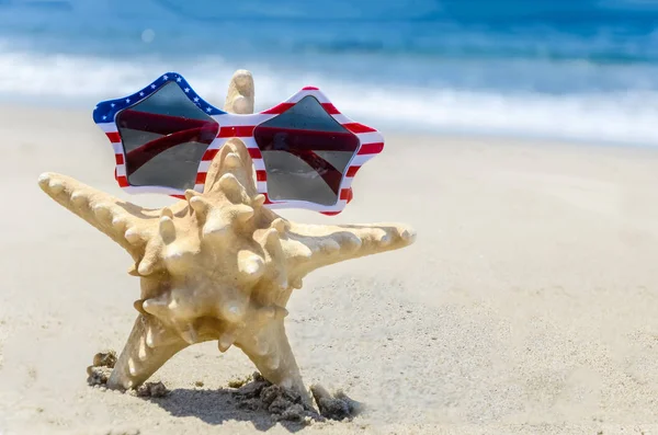 Patriotische USA Hintergrund mit Seesternen am Sandstrand — Stockfoto