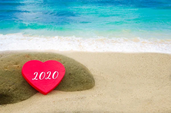 Symbol from number 2020 on the big heart on the sandy beach — Stock Photo, Image