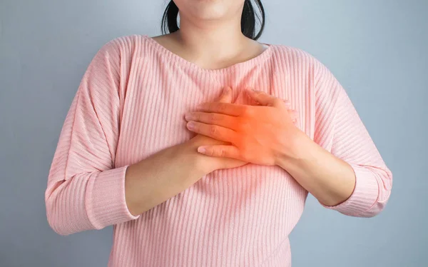 Asiática jovem mulher sofrendo de dor no peito causada pelo coração dise — Fotografia de Stock