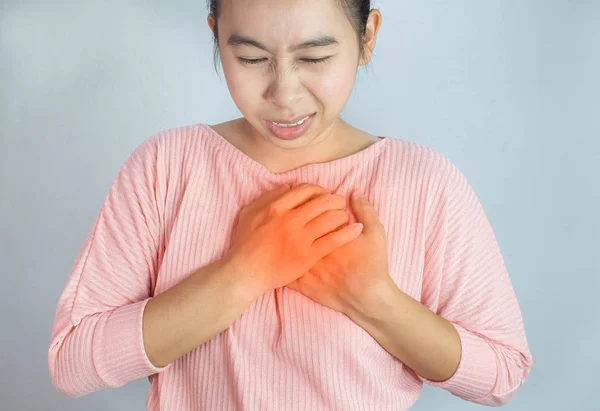 Asiática jovem mulher sofrendo de dor no peito causada por doença cardíaca . — Fotografia de Stock