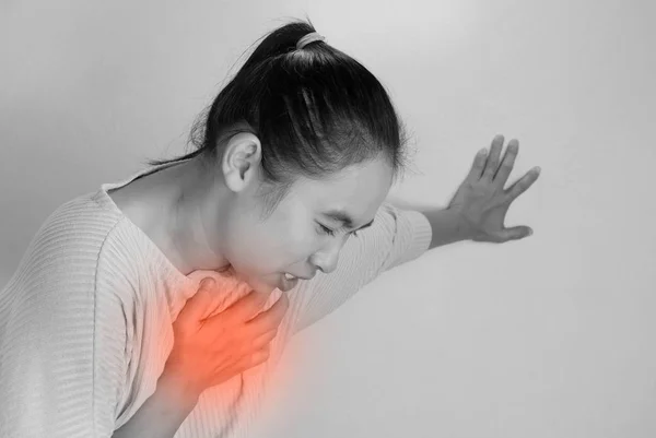 Asiática jovem mulher sofrendo de dor no peito causada por doença cardíaca . — Fotografia de Stock