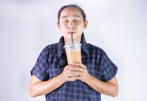 Feliz joven asiática está bebiendo té tailandés con leche. Bebida popular en Asia . —  Fotos de Stock