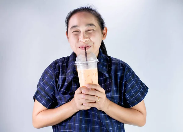 Feliz joven asiática está bebiendo té tailandés con leche. Bebida popular en Asia . —  Fotos de Stock