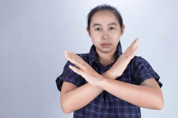 Retrato de una joven asiática con camisa azul, muestra el signo X en las manos con la cara seria aislada sobre fondo gris. Concepto de rechazo . — Foto de Stock