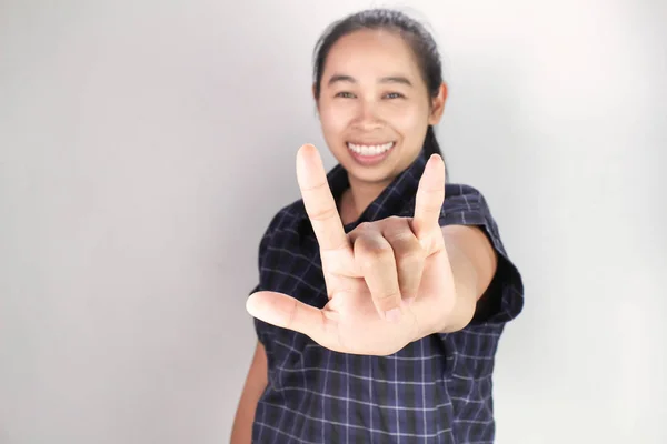 Retrato da jovem mulher asiática em camisa azul, Mostrando Eu te amo com linguagem corporal e rosto sorridente isolado em fundo cinza. Conceito de amor e preocupação . — Fotografia de Stock