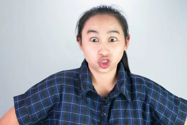 Ázsiai fiatal nő kék ingben, hogy vicces arcokat, hogy boldog és nem stresszes. Testbeszéd és bátorítási koncepció. — Stock Fotó