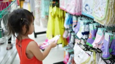 Kız kardeşiyle birlikte küçük sevimli Asyalı kız alışveriş merkezinde eğleniyor..