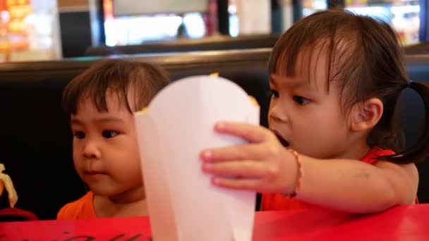 Happy Little Asian Child Girl Her Sister Eating French Fries — Stock Video