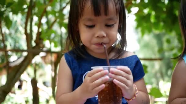 Pequena Menina Asiática Bebendo Sua Bebida Enquanto Sentada Descansar Parque — Vídeo de Stock