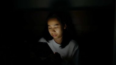 Geceleri yatak odasında tablet kullanırken Asyalı kadın uykulu oluyor. Teknoloji ve Sağlık Hizmetleri kavramı.