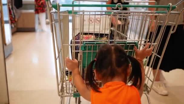 Маленька Дівчинка Допомагає Мамі Тримати Кошик Супермаркеті — стокове відео
