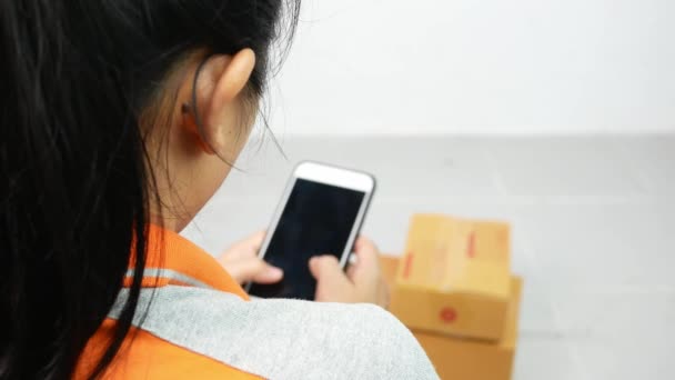 年轻的亚洲女人在家里用智能手机从事网上交易 网上业主的概念 — 图库视频影像