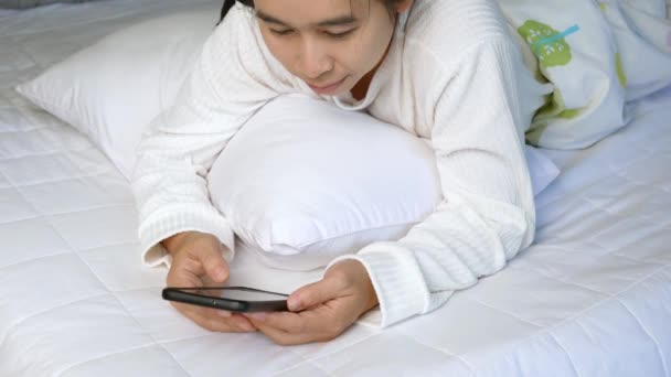 Asiatin Nutzt Smartphone Für Online Einkäufe Während Sie Hause Bett — Stockvideo