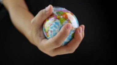 Kadın eli, dünyayı siyah arka planda plastik torba içinde tutuyor. Plastik molozların yol açtığı kirlilik nedeniyle küresel ısınma. Dünya Günü konsepti. 