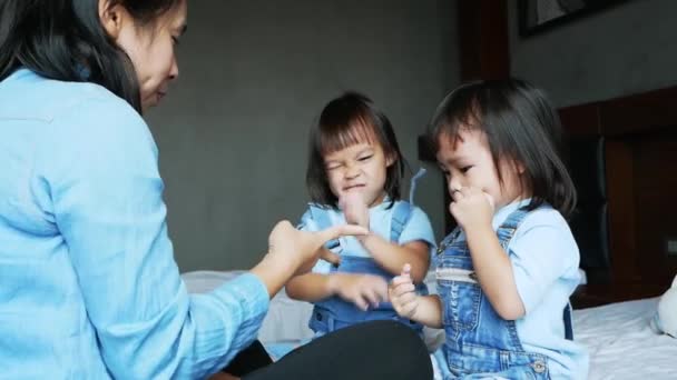 妈妈和她的女儿一起在卧室里玩耍 那孩子在床上玩石头剪子玩得很开心 假期内的家庭放松时间 — 图库视频影像