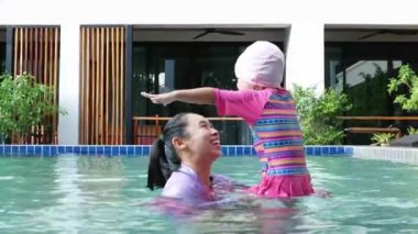 Mutlu Asyalı aile tatil beldesindeki yüzme havuzunda tatilin tadını çıkarıyor..