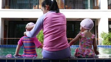 Mutlu Asyalı aile tatil beldesindeki yüzme havuzunda tatilin tadını çıkarıyor..