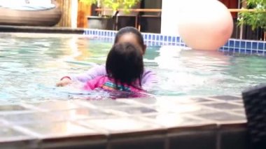 Mutlu Asyalı aile tatil beldesindeki yüzme havuzunda tatilin tadını çıkarıyor..