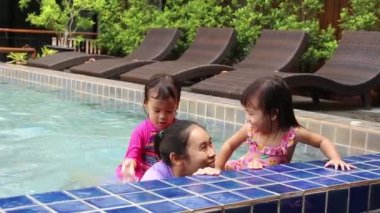 Mutlu Asyalı aile tatil beldesindeki yüzme havuzunda tatilin tadını çıkarıyor..