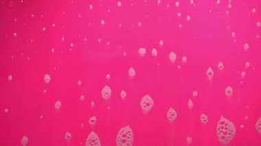Pembe arka planda akan sabundan köpük kabarcıkları.