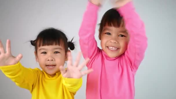 Πορτρέτο Ενός Χαρούμενου Χαμογελαστού Αδελφού Κοριτσιών Που Δείχνει Χαιρετώντας Χέρια — Αρχείο Βίντεο