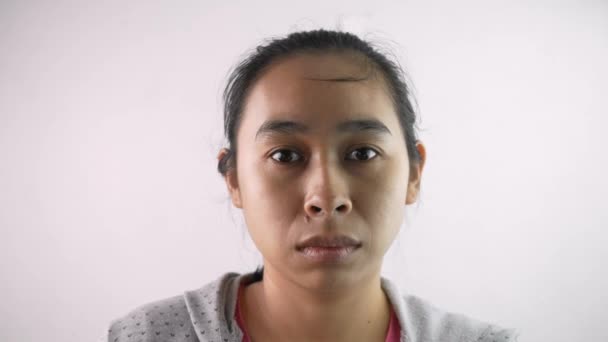 portrét depresivní mladé ženy bez make-upu a dívá se na fotoaparát s úzkostí.