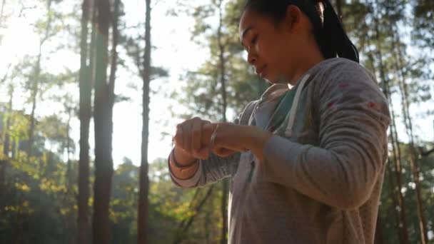 Asyalı Kadın Bahçede Koşmadan Önce Spor Uygulamasını Ayarlamak Için Bileğindeki — Stok video