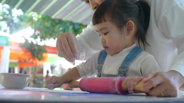 キッチンで自家製ピザの生地を準備している幸せな小さな子供の女の子と母親 家族の楽しさと料理のコンセプト — ストック動画