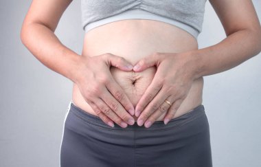 Close up of Woman touching belly skin with stretch marks and loo clipart
