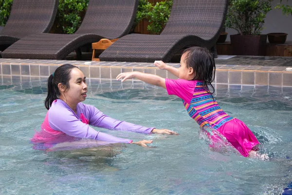 Happy Asian family enjoying summer vacation in swimming pool at — Stock Photo, Image