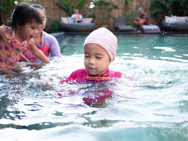 아시아의 행복 한 가족들 이 수영장에서 여름 방학을 즐기는 모습 — 스톡 사진