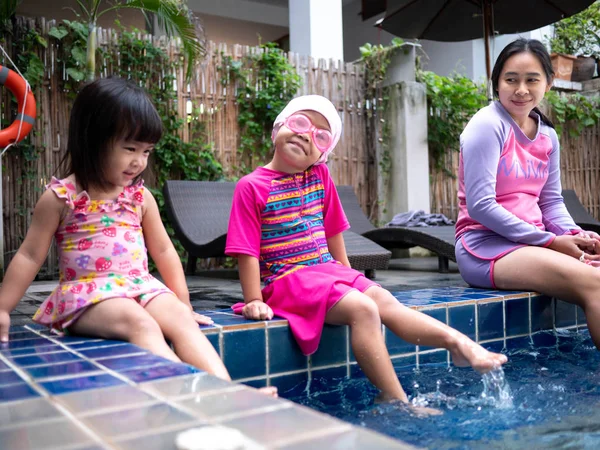 아시아의 행복 한 가족들 이 수영장에서 여름 방학을 즐기는 모습 — 스톡 사진