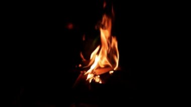 Gece gökyüzünde kıvılcımlar saçan kavurucu bir ateş. Ateşin güzel soyut arkaplanı siyah arkaplanda parçacıkları ateşler.