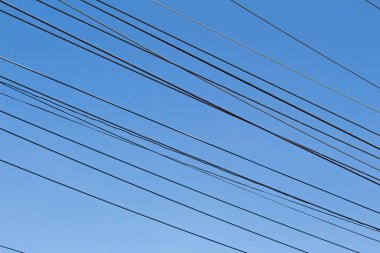 Mavi gökyüzü arka plan üzerinde elektrik telleri.