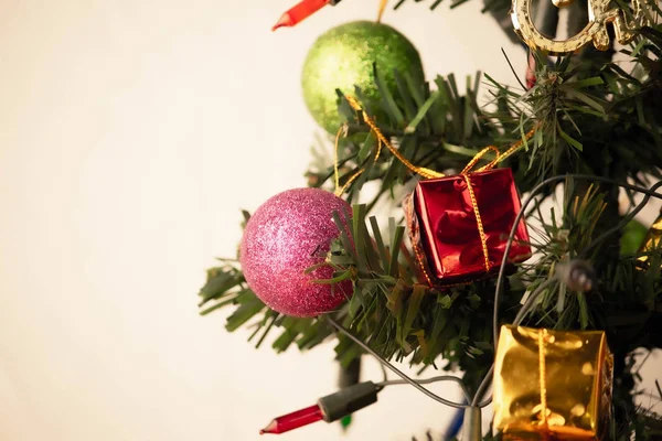 Közelről rózsaszín csecsebecse lóg egy díszített karácsonyfa — Stock Fotó