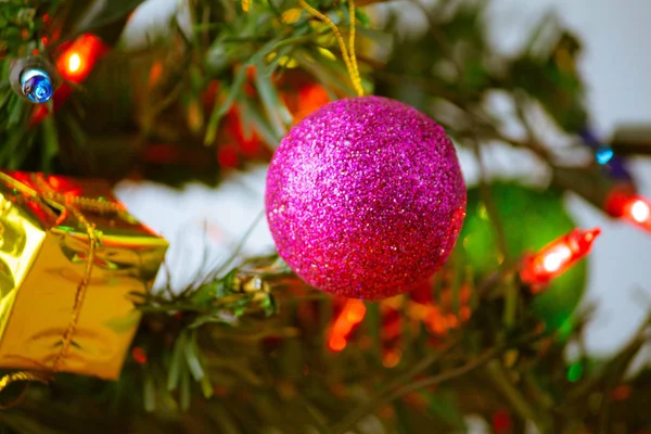 Közelről rózsaszín csecsebecse lóg egy díszített karácsonyfa — Stock Fotó