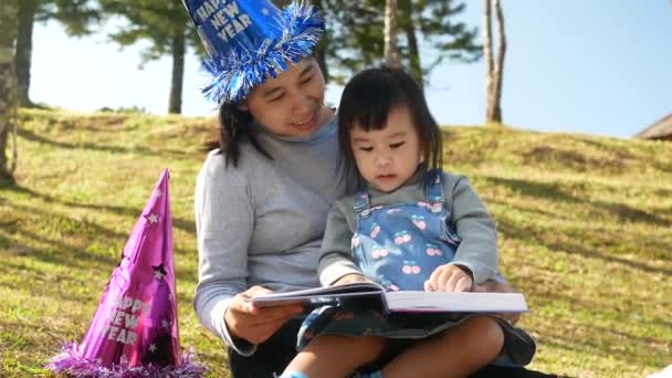 Asijská Matka Čte Knihu Své Dceři Jarní Zahradě Rodinný Čas — Stock video