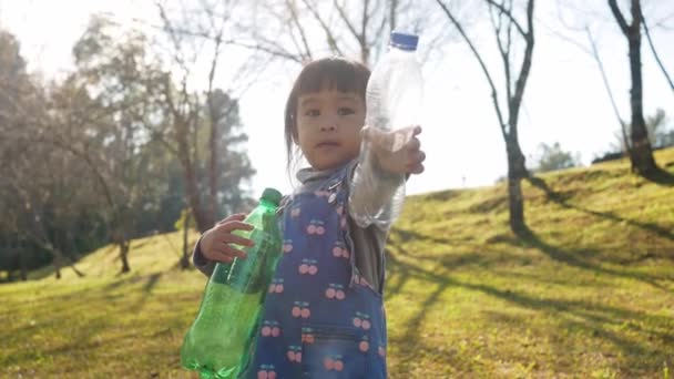 Kleine Mädchen Sammeln Park Wasserflaschen Plastiktüten Die Sie Recyceln Können — Stockvideo