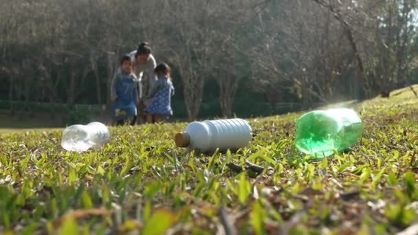 アジアの家族は ゴミをプラスチック製の袋に捨てることを拒否した人々からペットボトルを回収してリサイクルすることで庭をきれいにするのに役立ちます 環境の保全と廃棄物の削減 — ストック動画