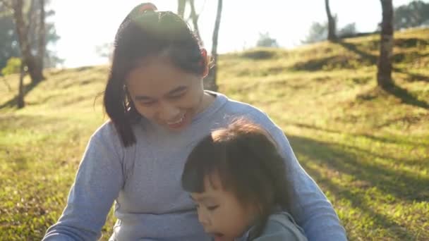 Mãe Asiática Lendo Livro Para Sua Filha Jardim Primavera Família — Vídeo de Stock