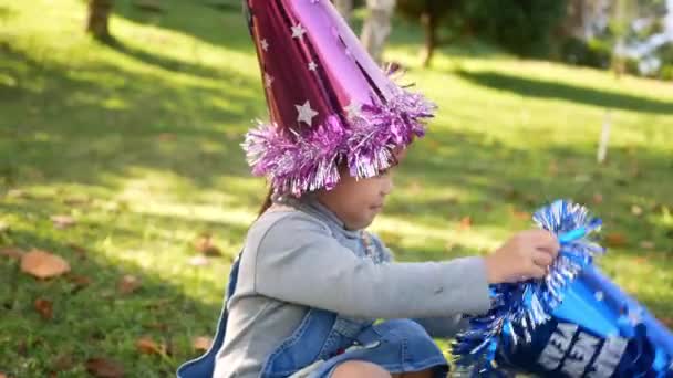 Αξιολάτρευτο Κοριτσάκι Που Φοράει Καπέλο Πρωτοχρονιάς Χαρούμενο Χαμόγελο Στον Κήπο — Αρχείο Βίντεο