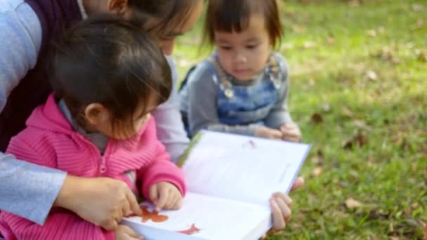 Madre Asiática Leyendo Libro Sus Hijas Jardín Primavera Familia Pasar — Vídeo de stock