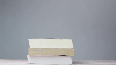 Birçok eski kitap masaya düştü ve odanın her tarafına toz yayıldı..