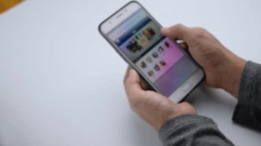 Akıllı telefondan satın almak için kullanılmış araca bakan bir kadına yaklaş. Seçici odak.